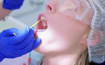 Dentist make fluoridation of teeth after ultrasonic cleaning for young woman. Stomatologist apply fluoride on patient's teeth. Portrait of young woman. Stomatology clinic, cure, treatment, procedure.
